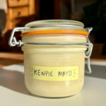 Glass jar with a label saying kewpie mayo on it.