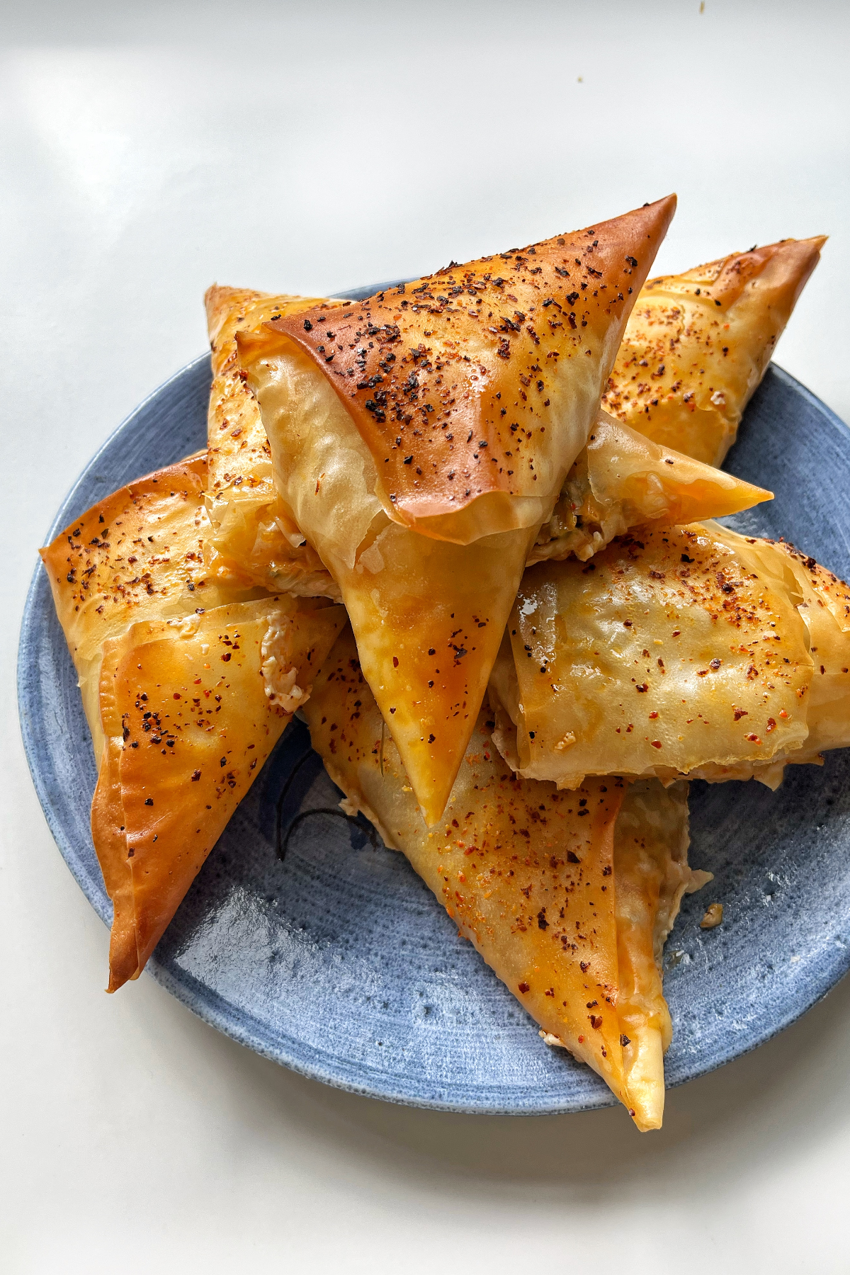 chilli oil feta pastries placed on a blue plate.