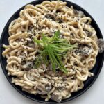 Creamy udon dish on a black plate