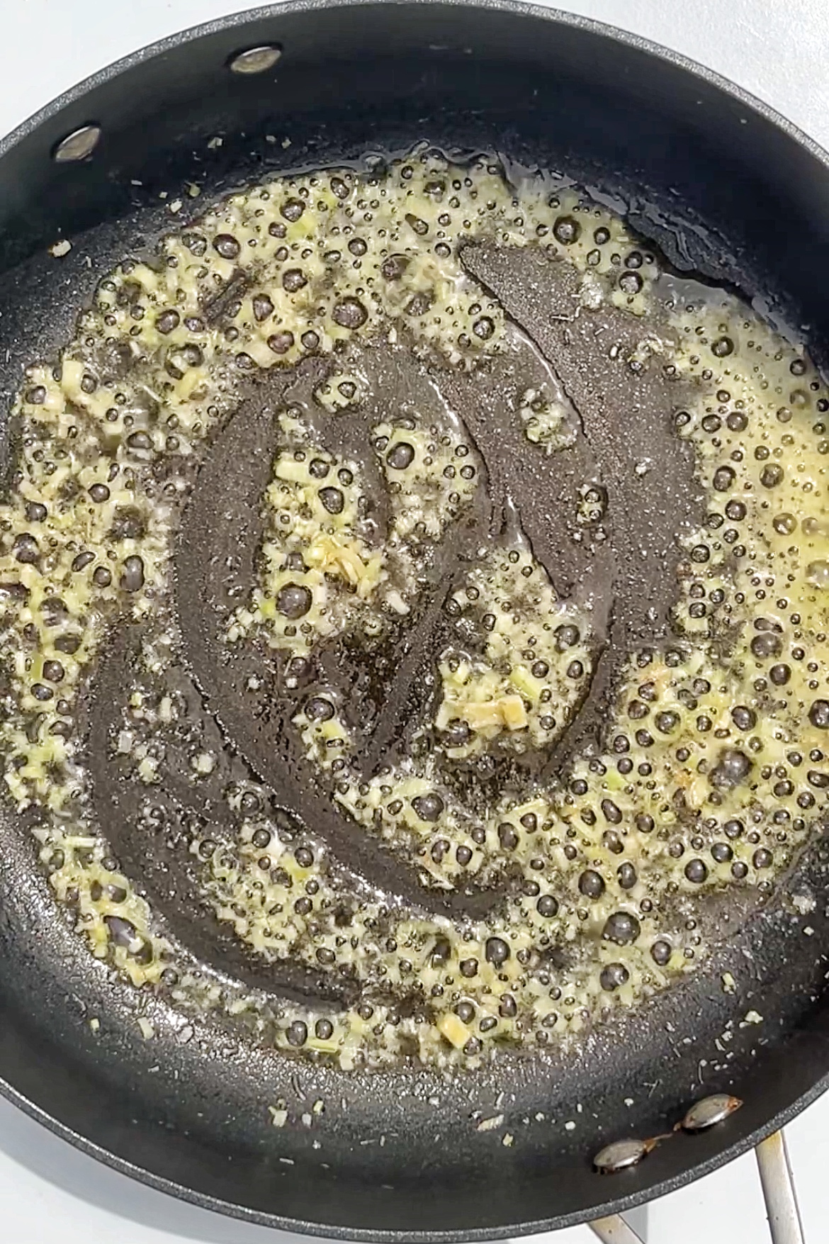 Lemongrass and coconut frying in pan.