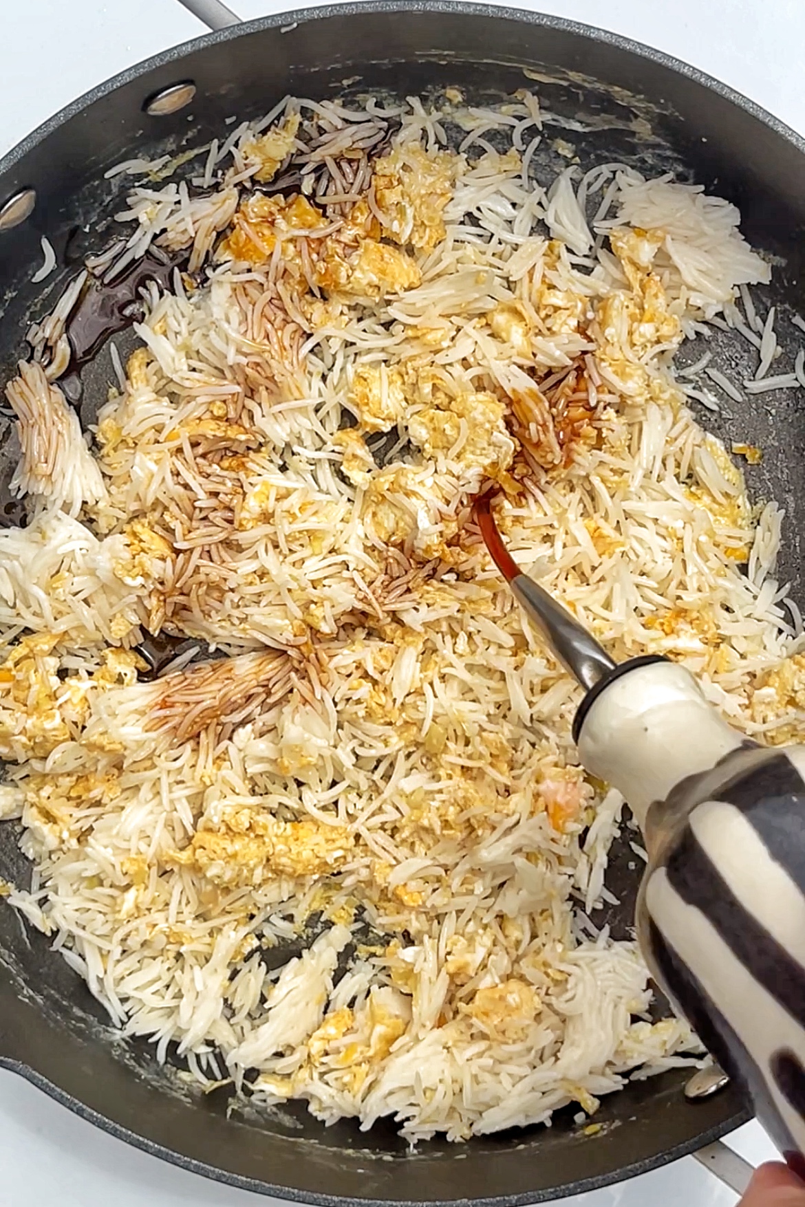 Adding soy sauce into fried rice