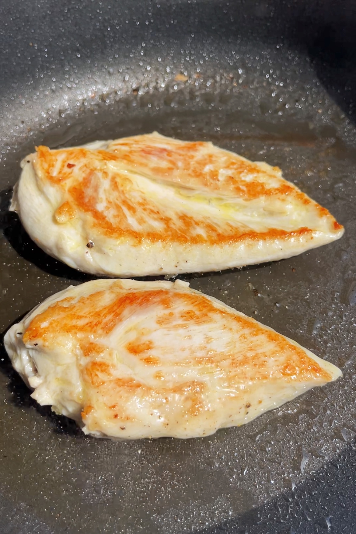 Pan frying chicken breast.