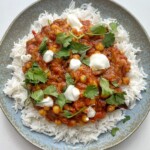Aubergine tikka masala on blue plate.