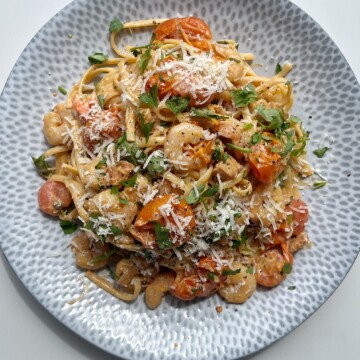 Creamy prawn and chorizo linguine on a light blue plate.