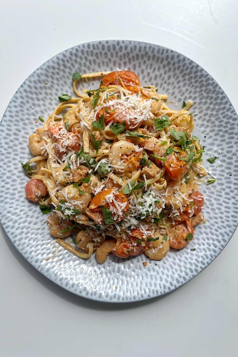 Creamy prawn and chorizo linguine on a light blue plate.