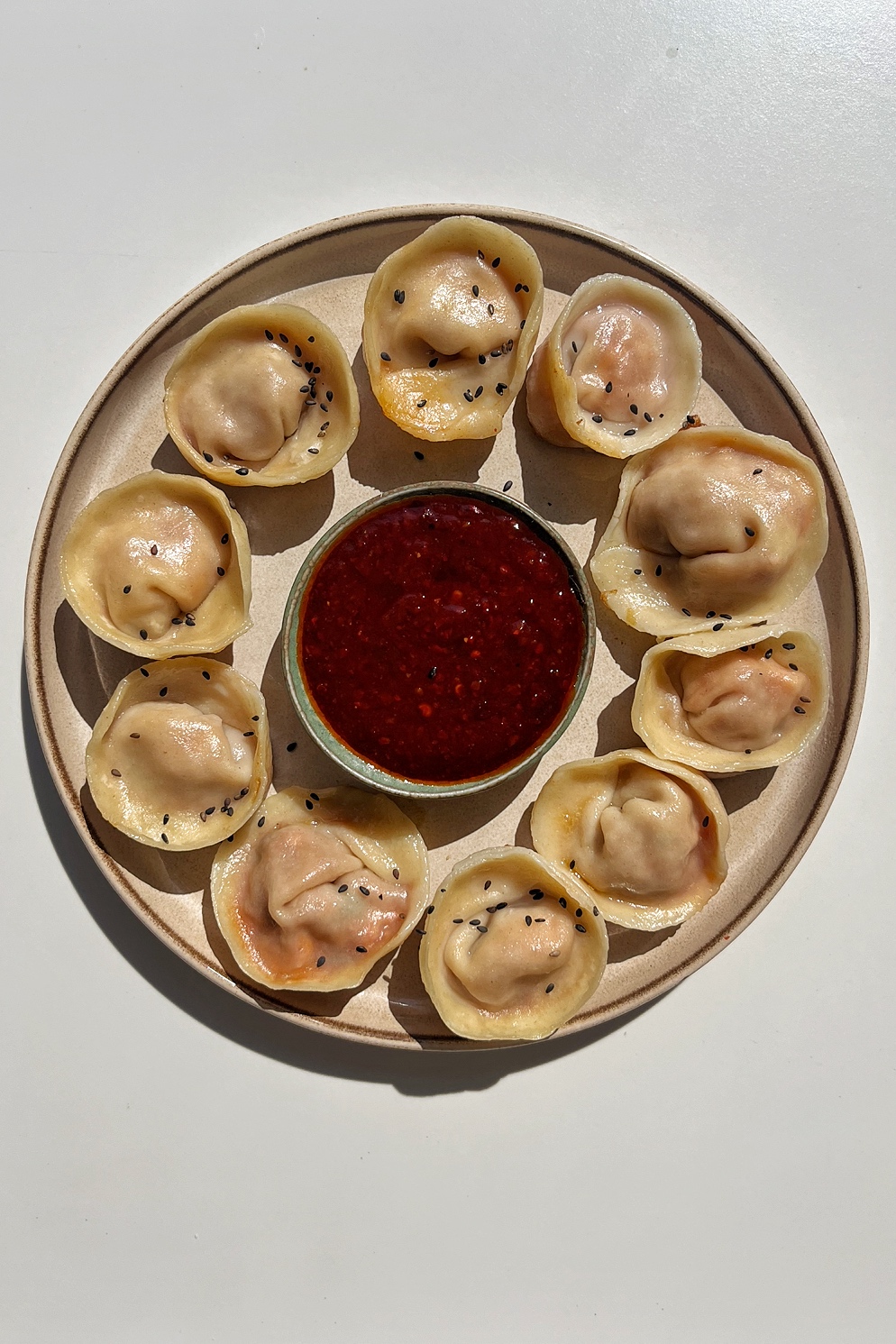 Mandu dumplings on a cream plate.