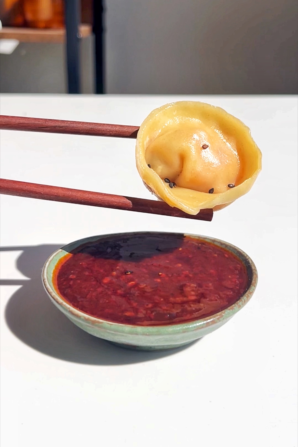 Korean mandu about to get dipping in a gochujang dipping sauce.