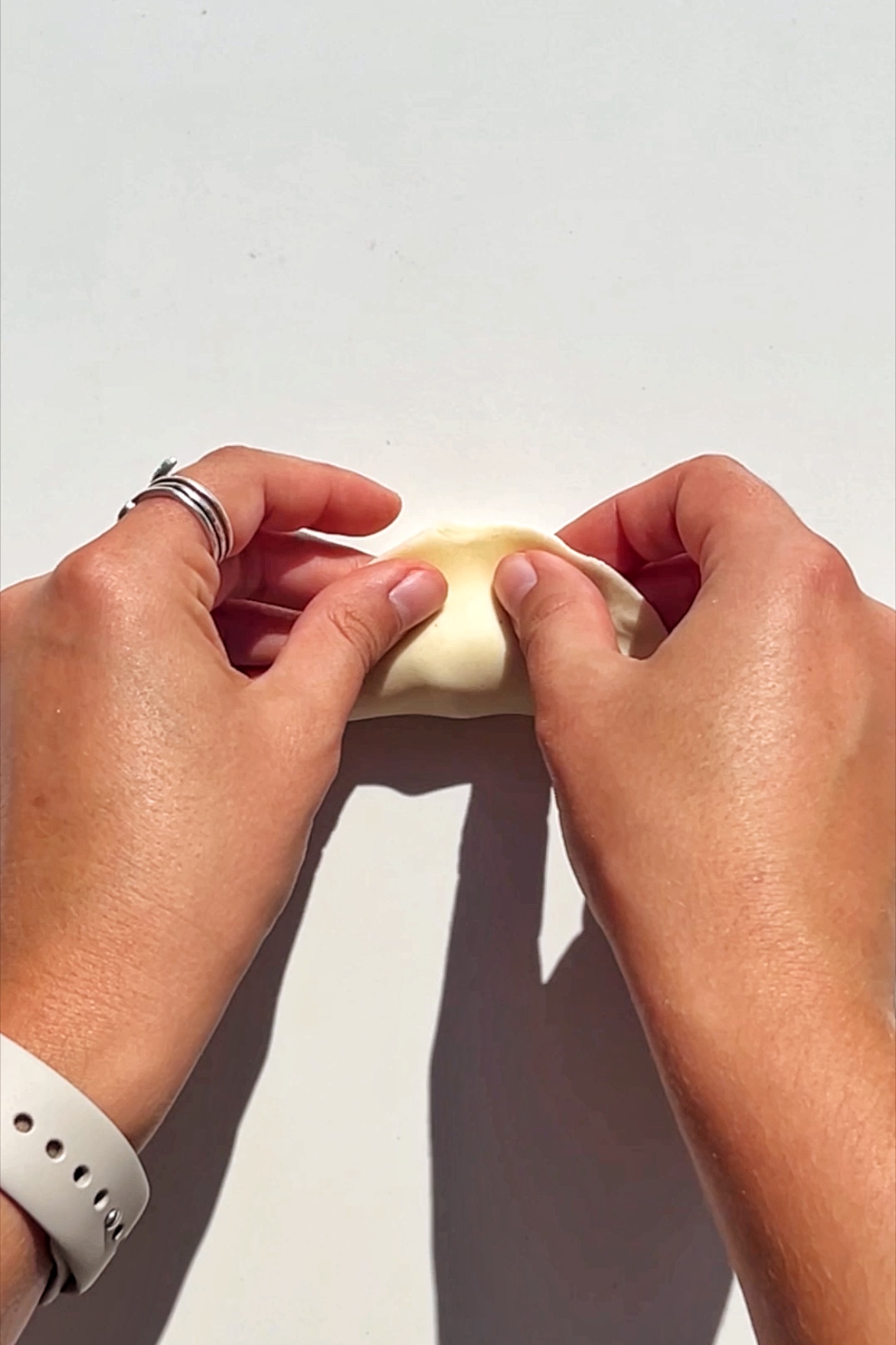 Folding over the dumpling wrapper.