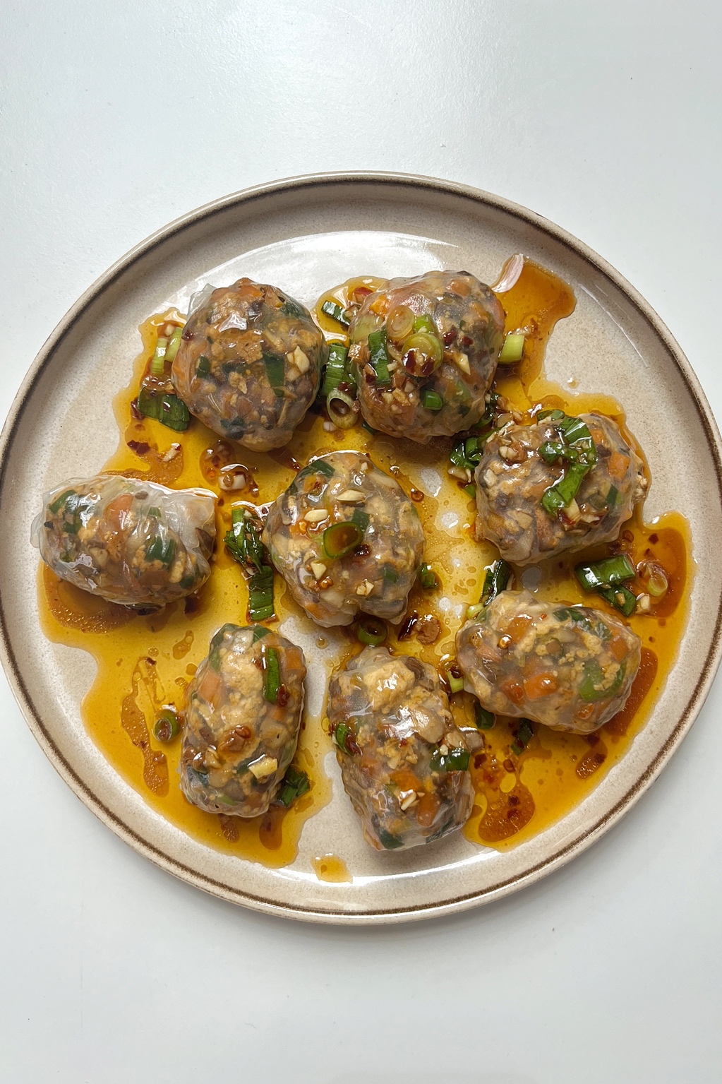 Steamed rice paper dumplings on cream plate.