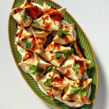 Shot of honey harissa sausage dumplings on green plate.