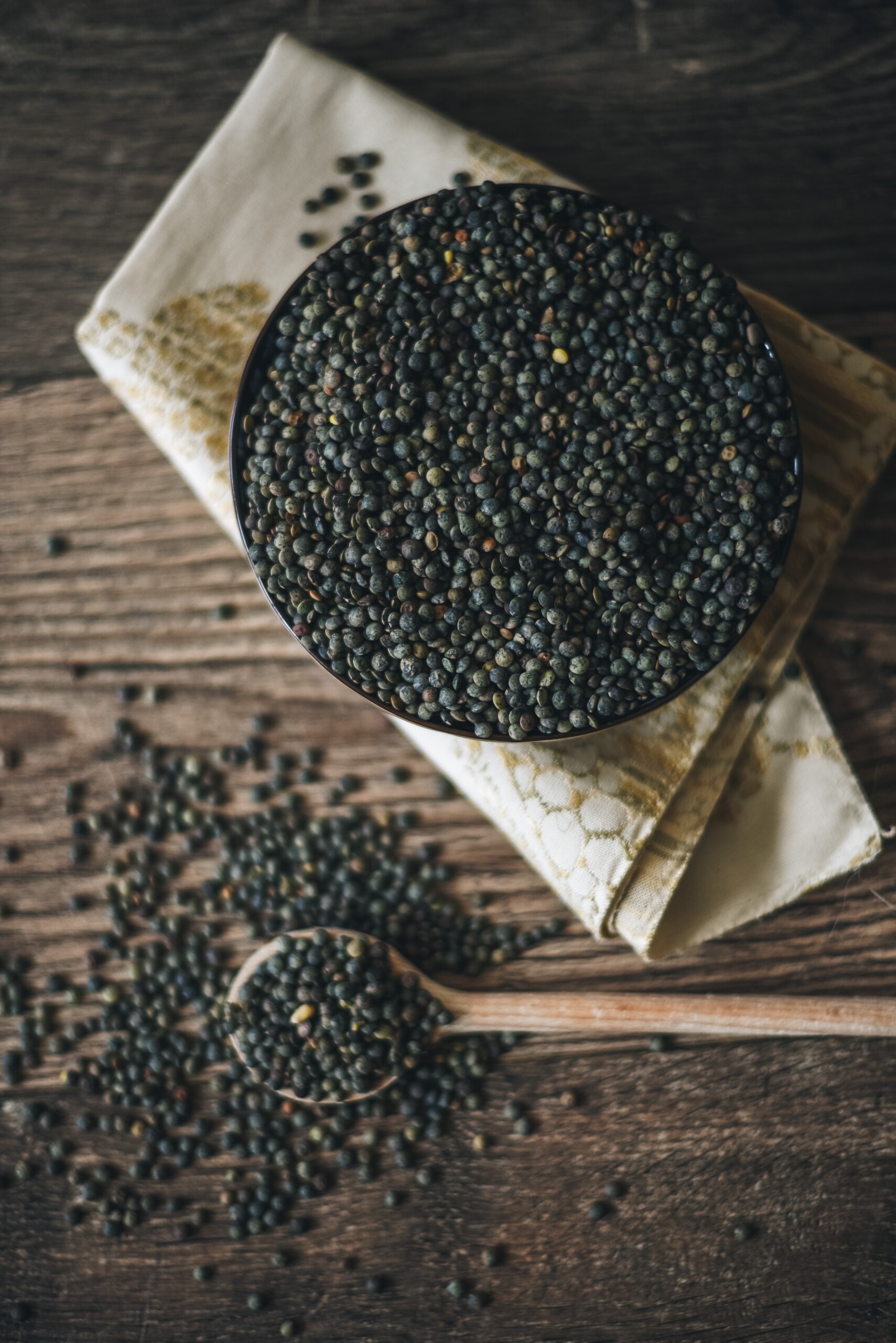 Green lentils close up in a bowl.