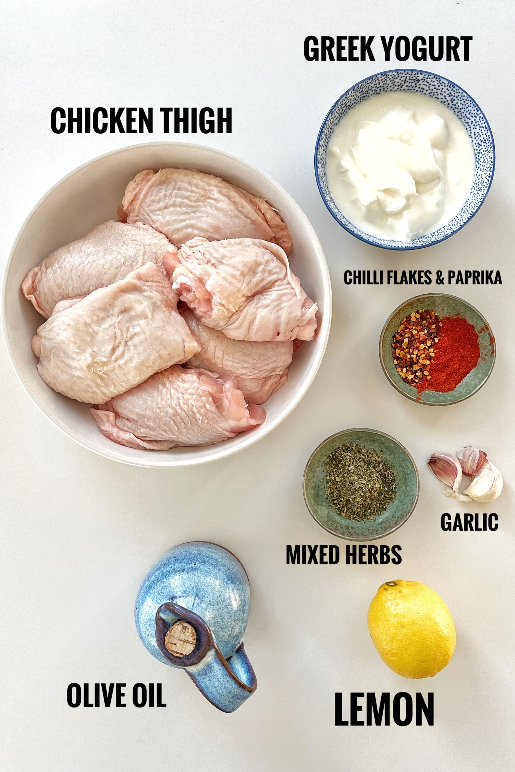 All the ingredients needed for this Greek yogurt chicken in the air fryer on white surface.