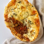 French onion cottage pie with chunk taken out of it.