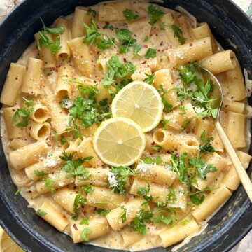 Black cast iron pan with lemon Boursin pasta inside topped with lemon slices.
