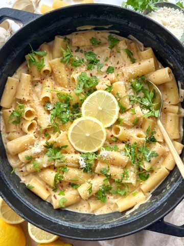 Black cast iron pan with lemon Boursin pasta inside topped with lemon slices.