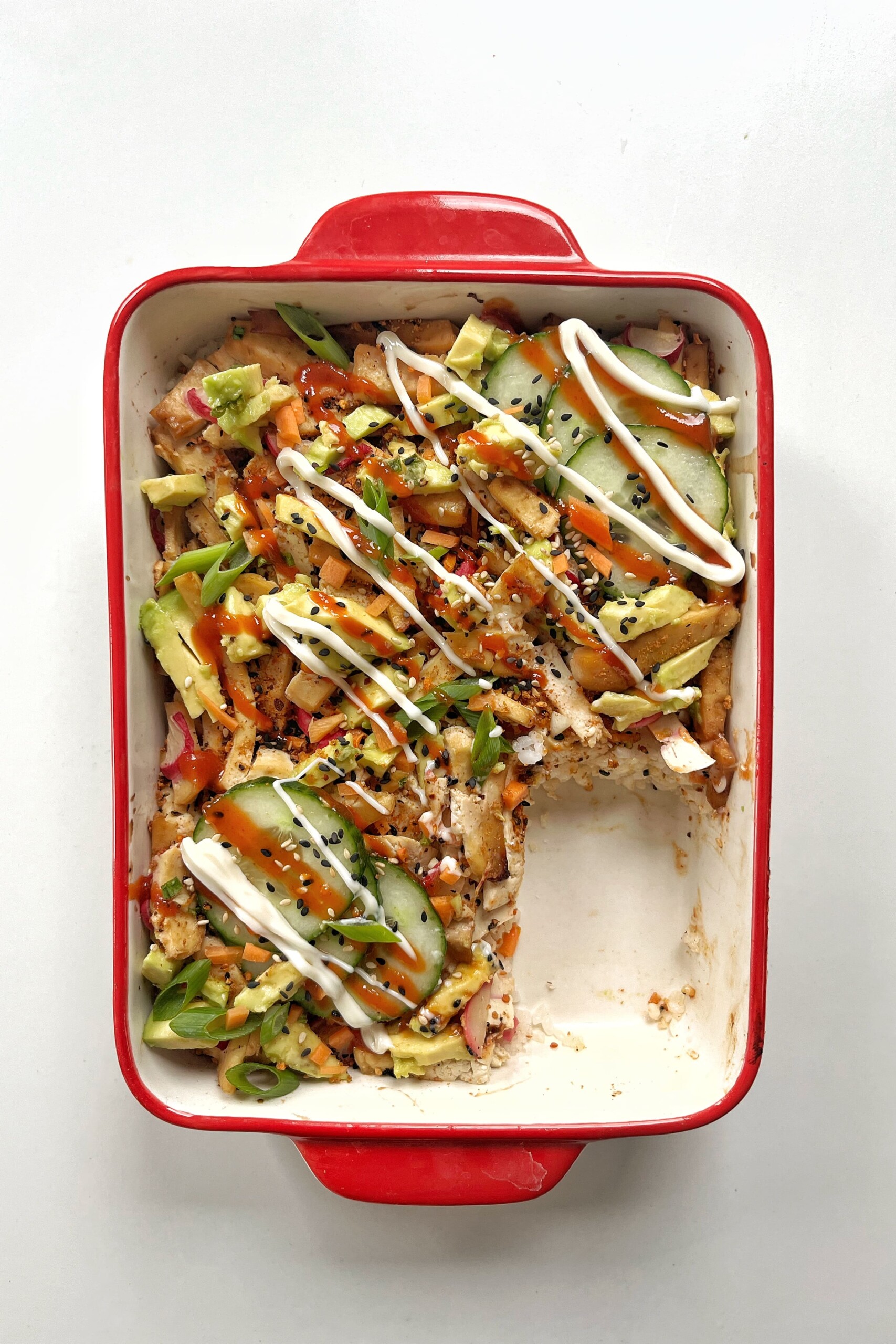 Vegan sushi bake with a piece missing.