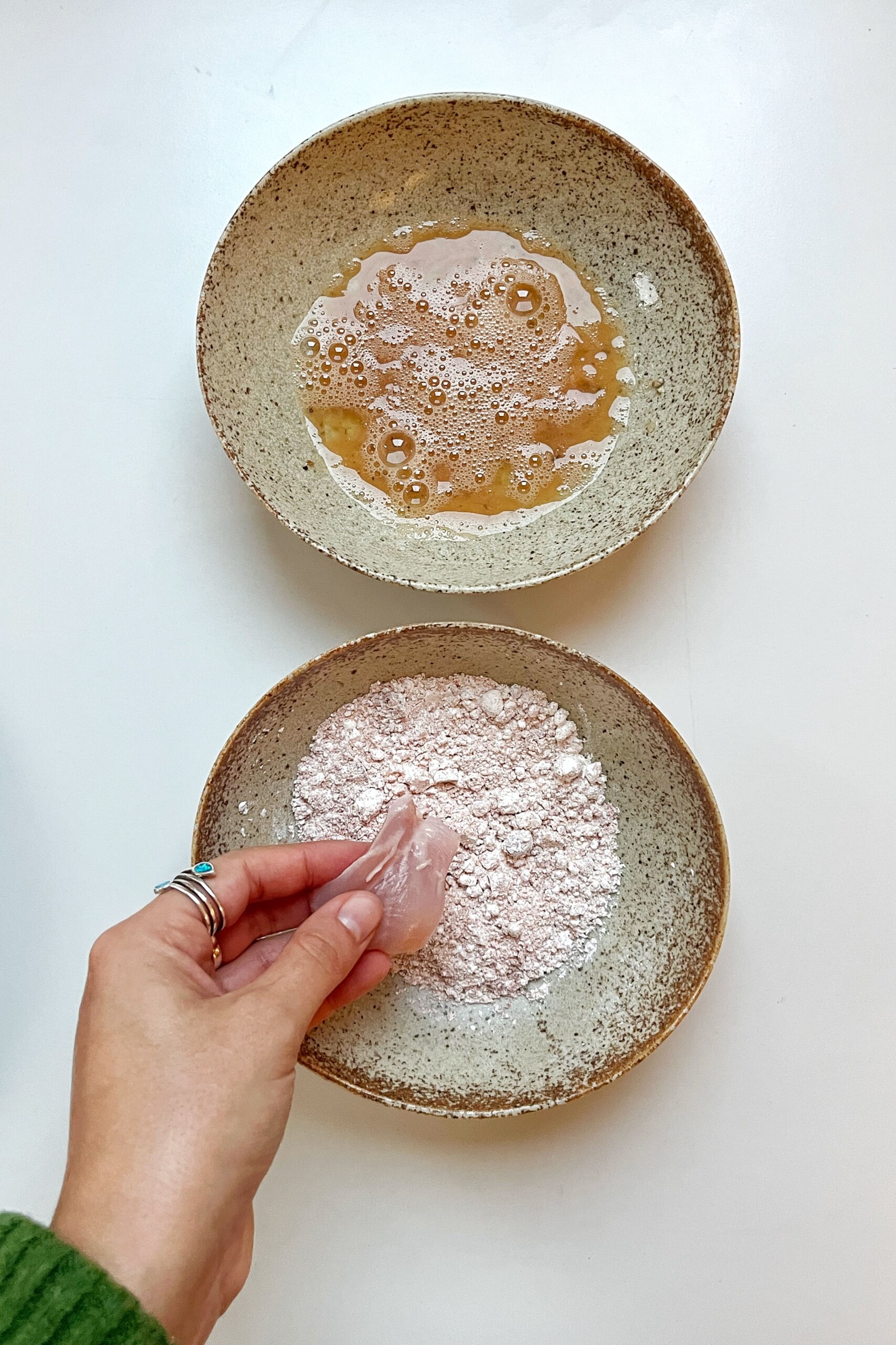 Coating chicken with flour and egg.