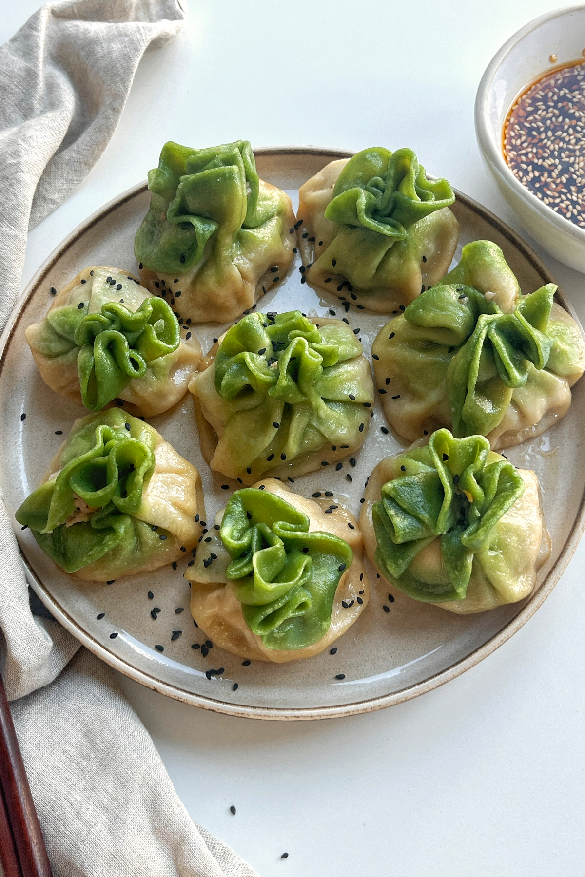 Green and white dumplings on a plate.