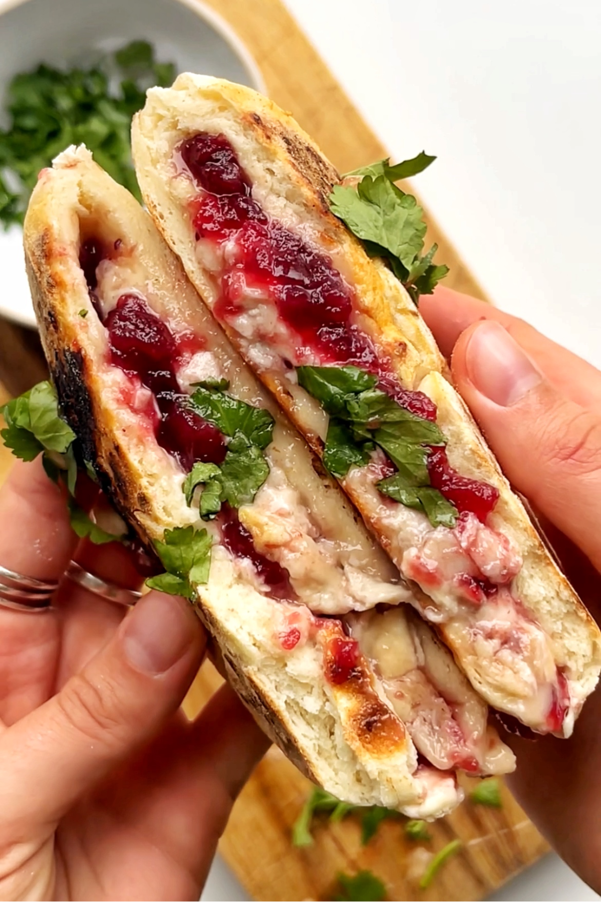 Opening of a festive turkey flatbread with cranberry sauce, brie, and turkey.