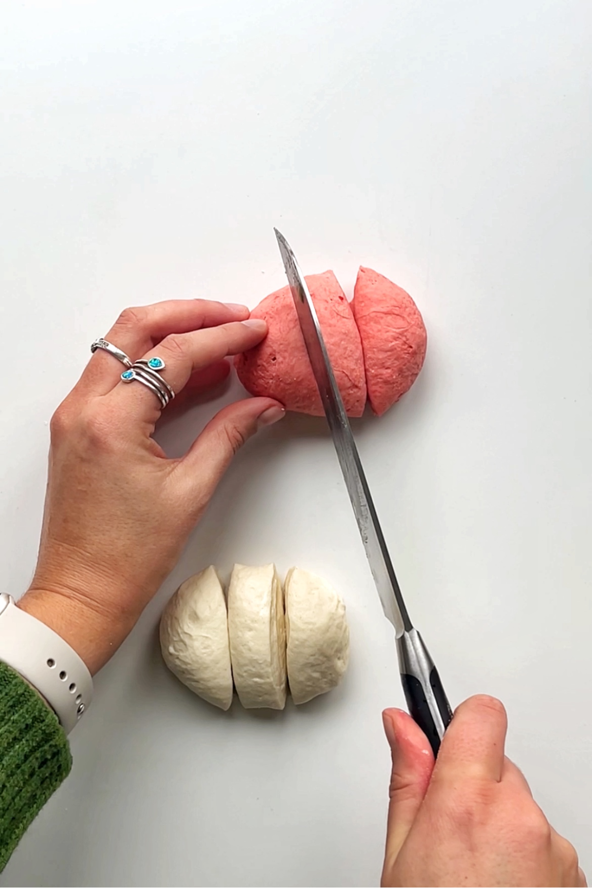 Chopping up pink and white dough.