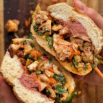 Opened up sandwich with pate, chicken, herbs, and pickles.