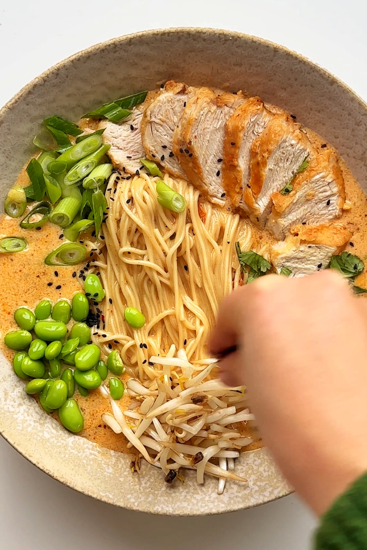 Adding toppings onto a ramen.