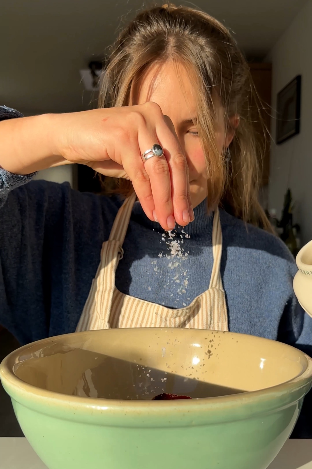 Making the filling for dumplings in a green bowl.