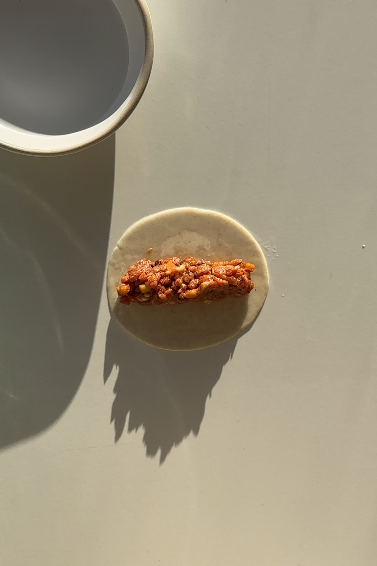 Dumpling wrapper with dumpling filling in the centre.