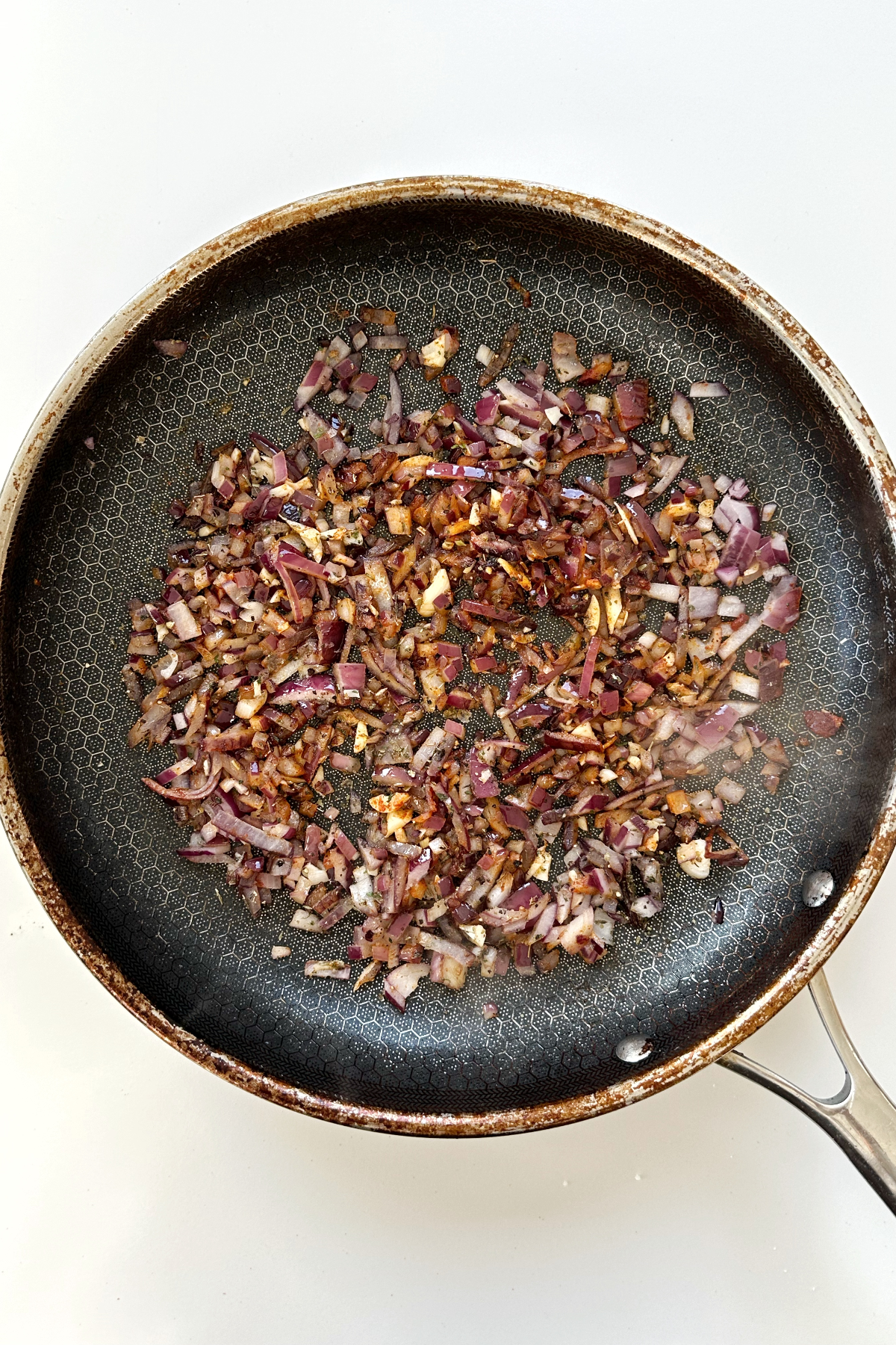 Frying garlic and onion in a black pan.