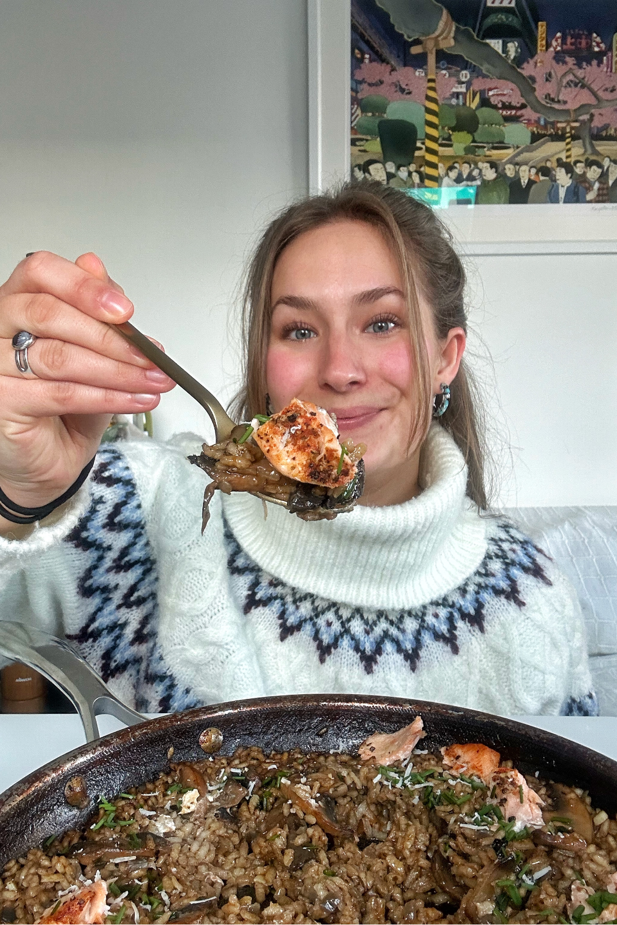 Emily Roz holding a spoon of mushroom and salmon risotto.