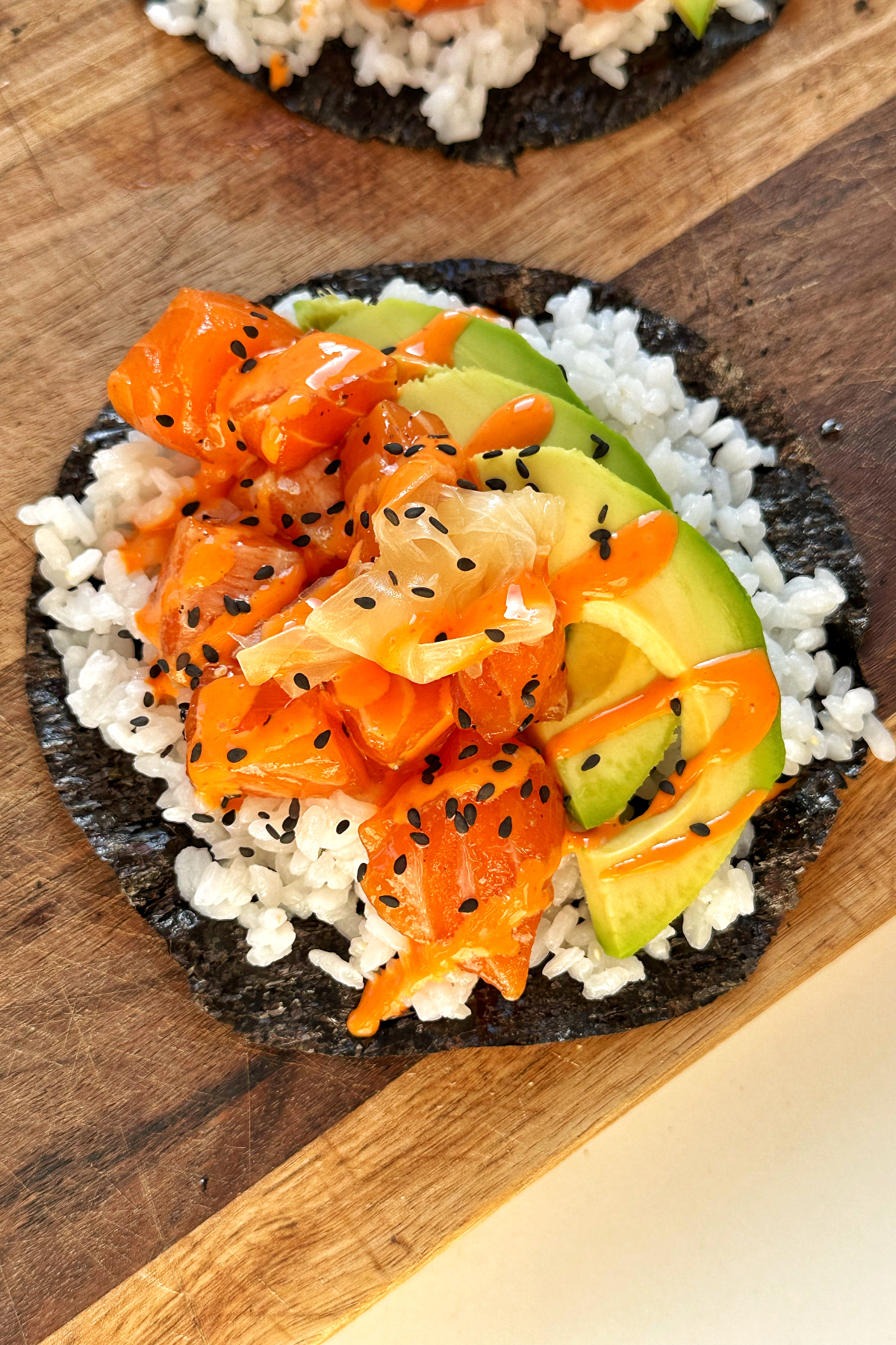 Sushi taco on a chopping board with avocado and salmon.
