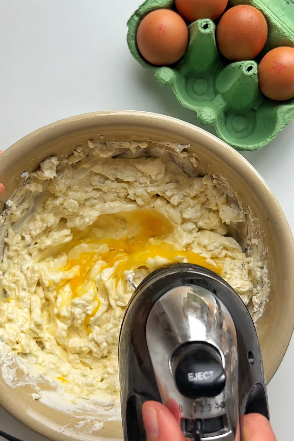 Whisking egg in a cheese bowl.