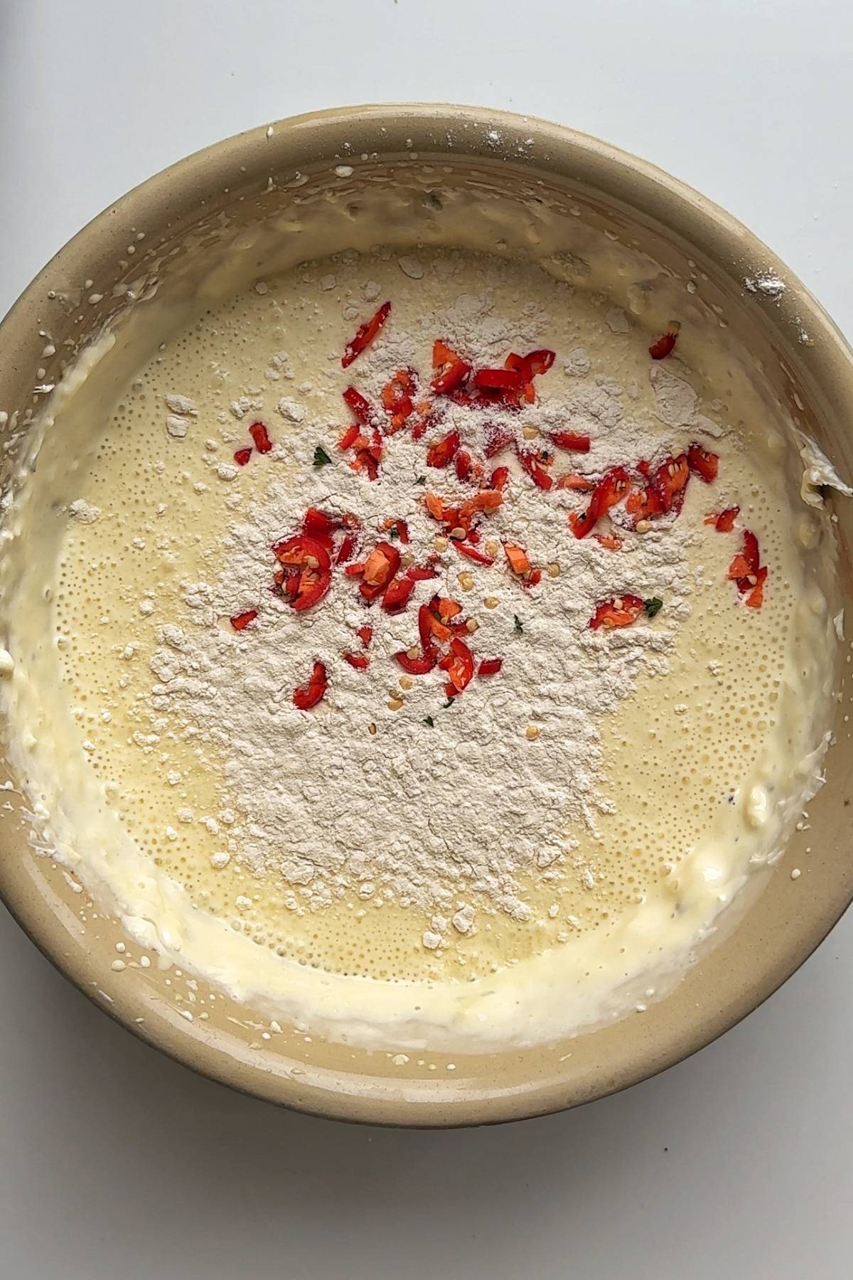 Adding flour and chillies to the burnt Basque cheesecake mixture.