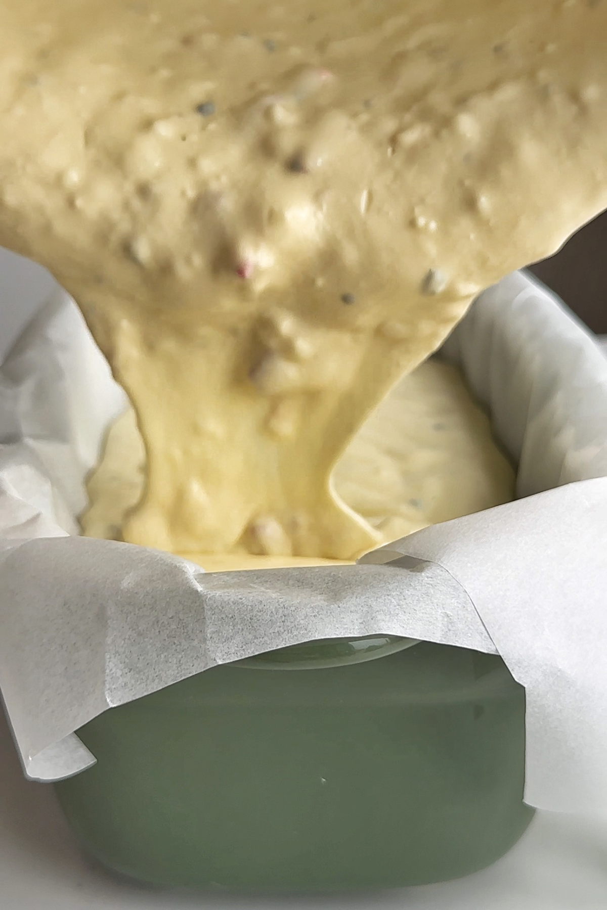 Pouring the savoury cheesecake mixture into a baking loaf dish.