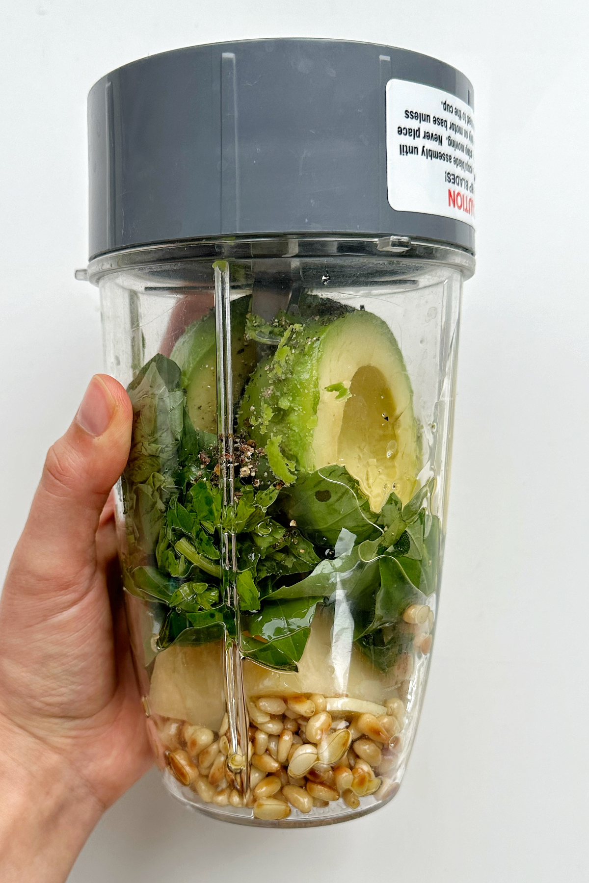 Blending all the avocado pesto ingredients in a blender.