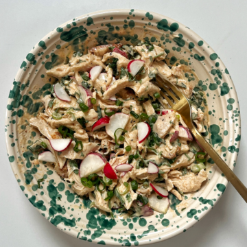 Bowl with chicken salad inside and a fork coming out of it.