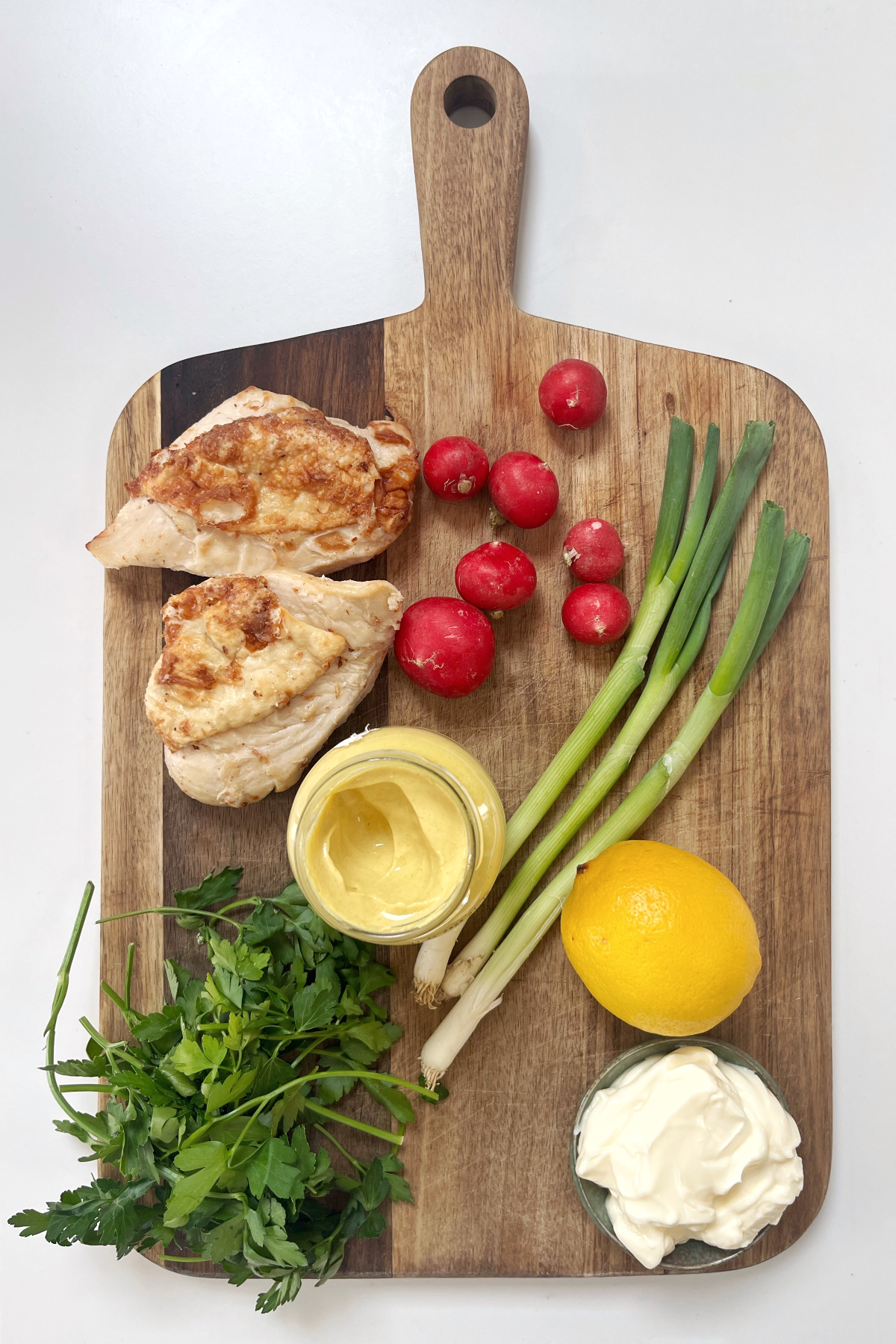 Ingredients for chicken salad on a chopping board.