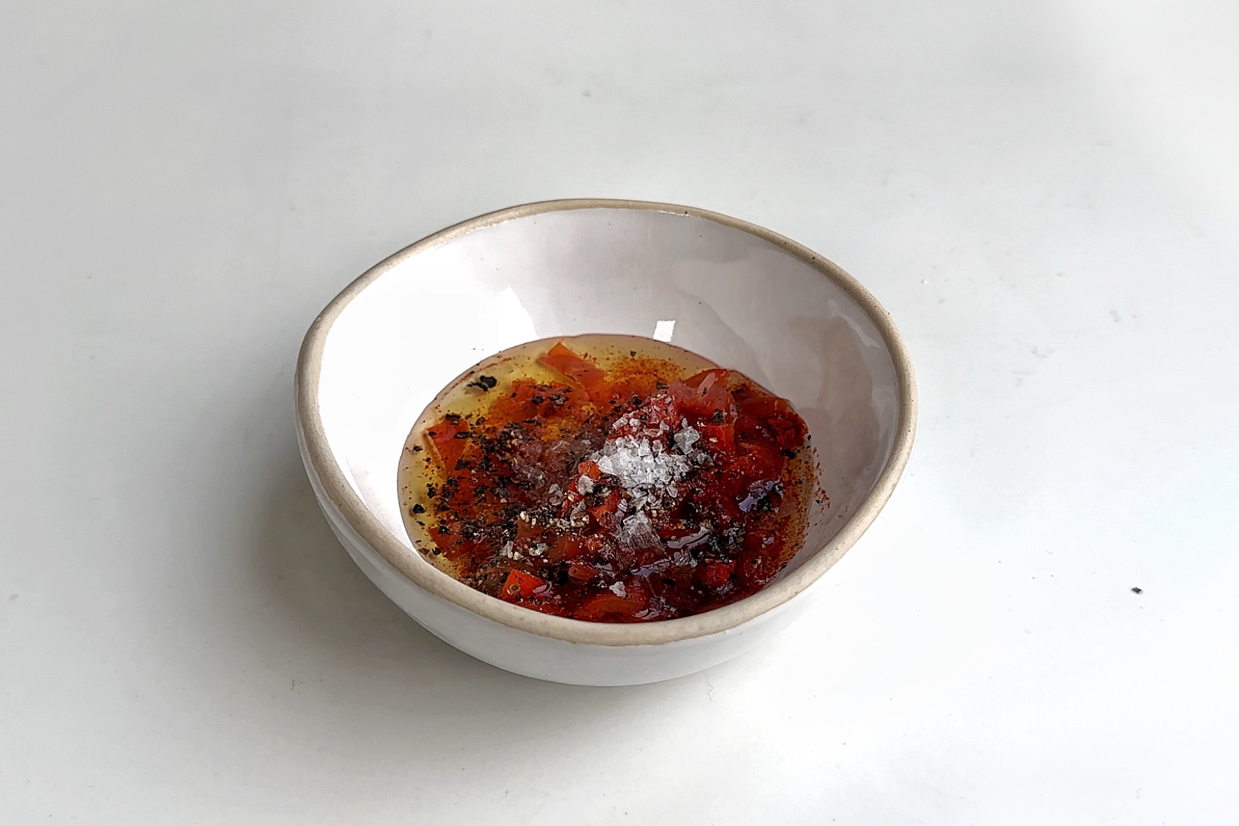 White bowl filled with a smoked paprika and tomato drizzle.