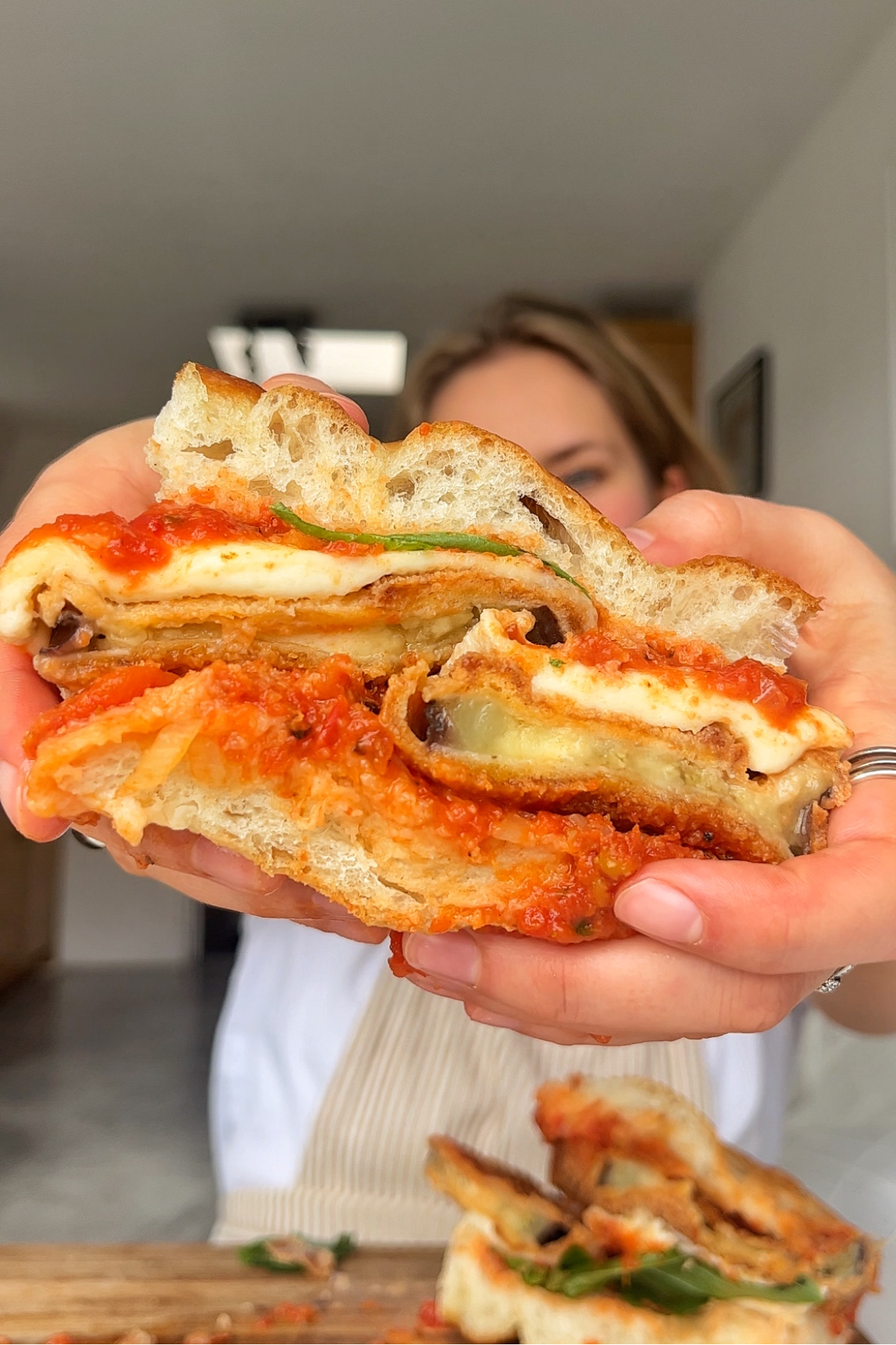 Eggplant parmesan sandwich being held up to the camera.