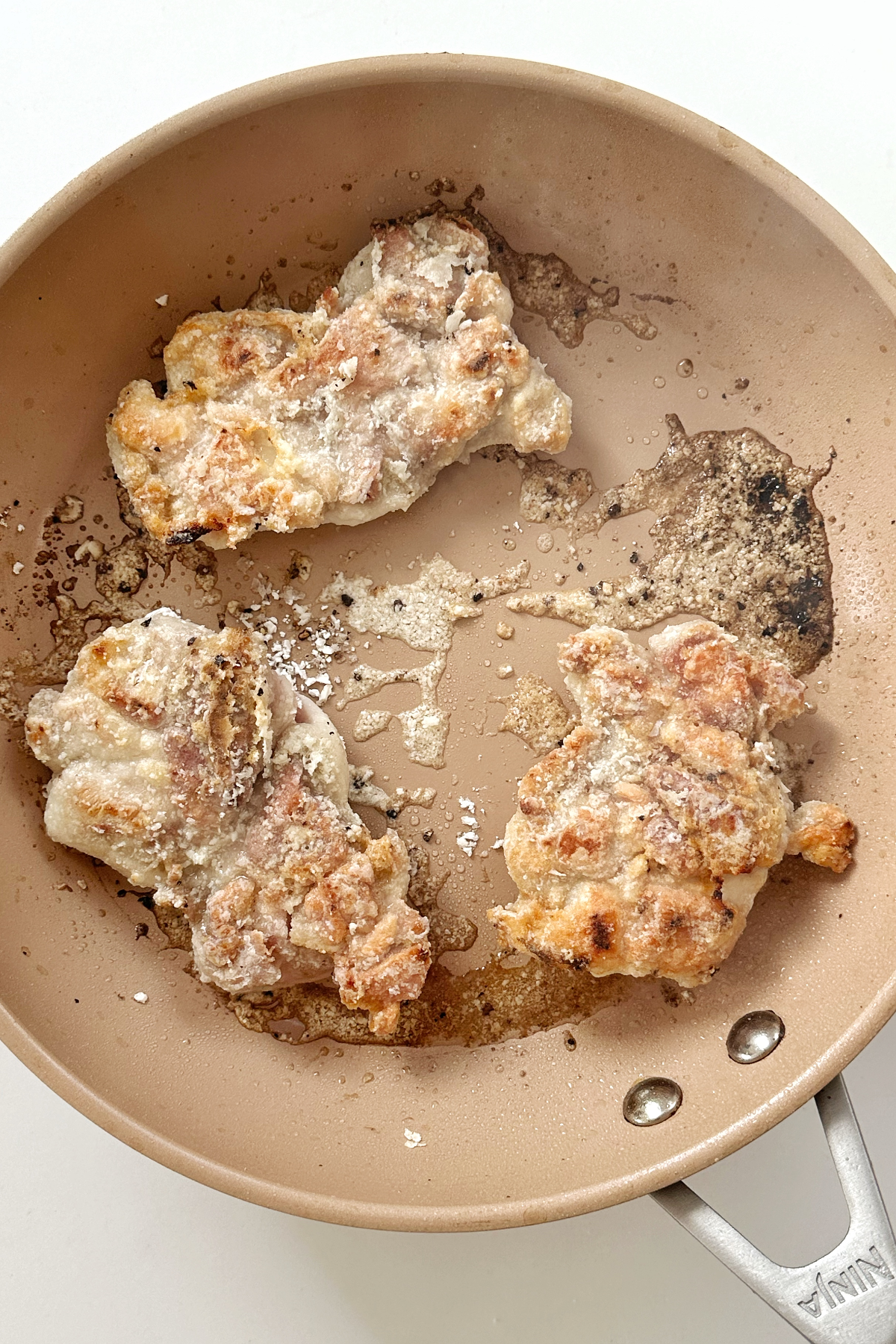 Frying cornstarch chicken thighs in non-stick frying pan.