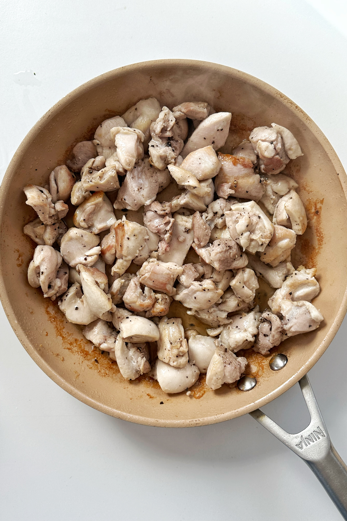 Frying chicken in a non-stick frying pan.