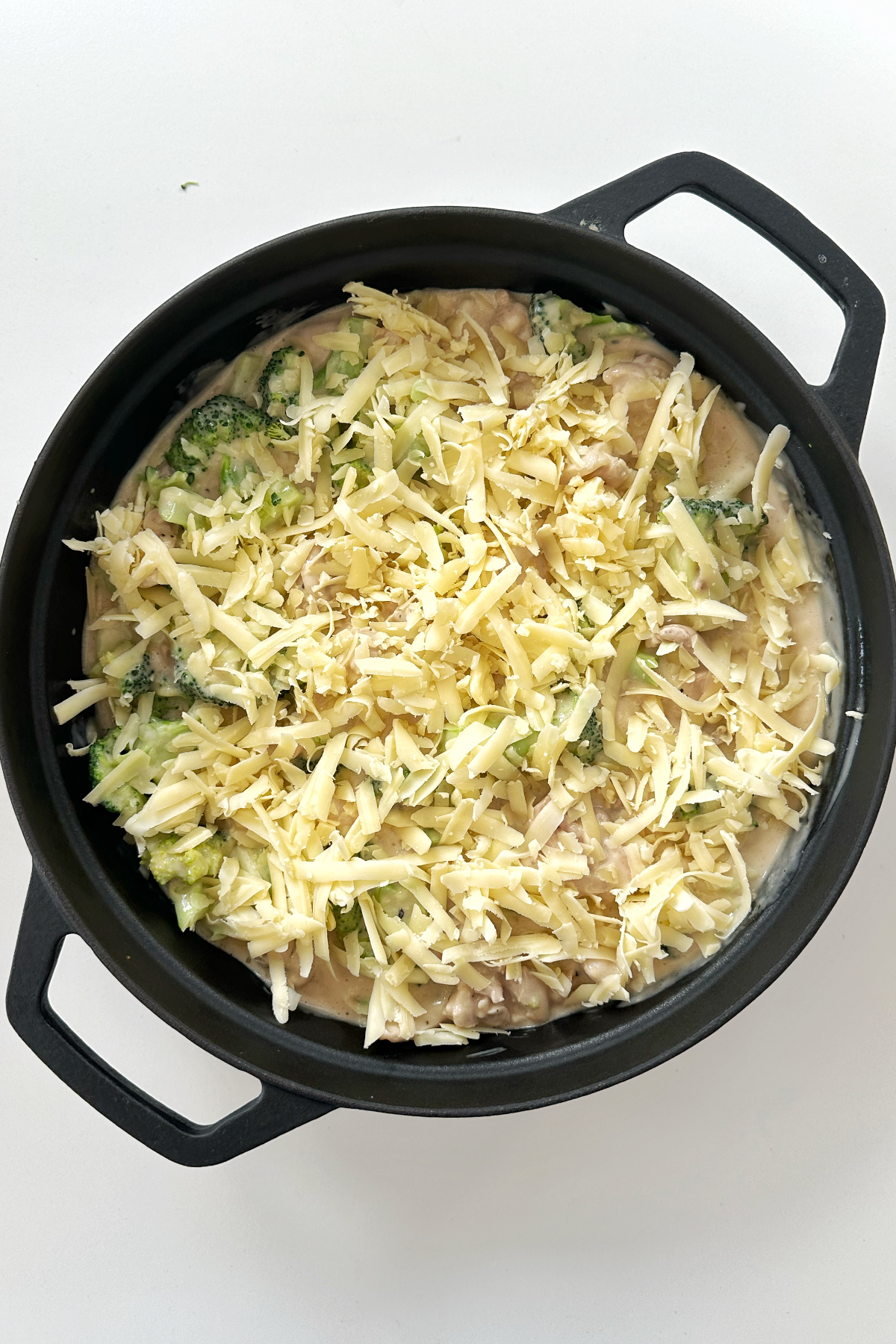 Nixon's chicken casserole in a black dish topped with cheddar cheese.