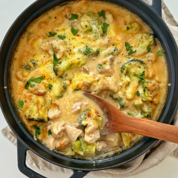 Chicken casserole in a black dish with a wooden spoon.