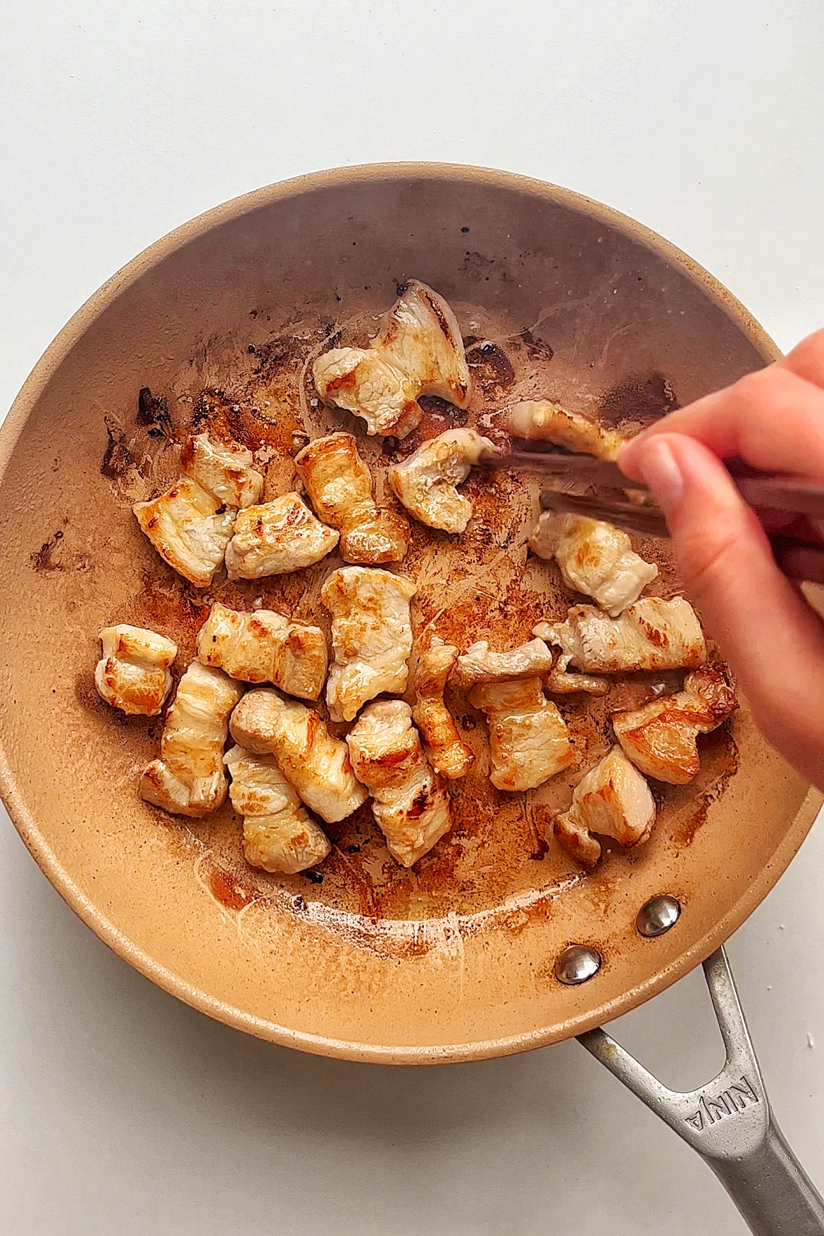Frying pork belly in a frying pan.