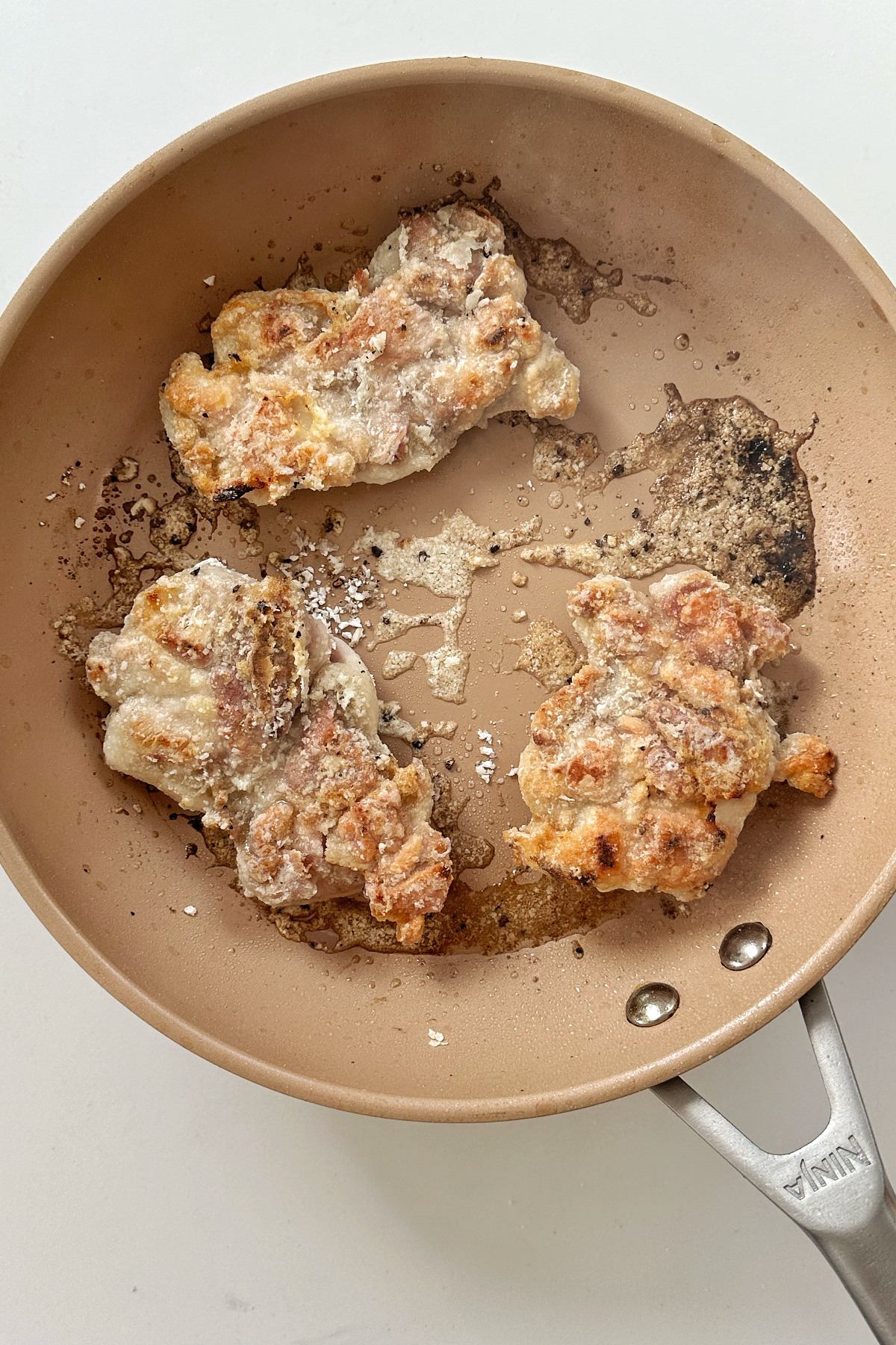 Frying cornstarch chicken thighs in a frying pan.