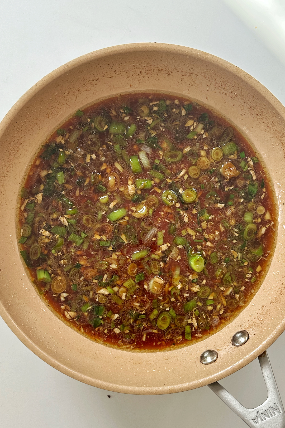 Frying scallions with ginger, garlic, in light soy sauce.