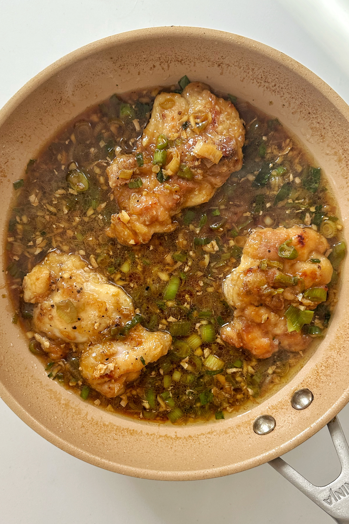 Scallion chicken with ginger in a pan.