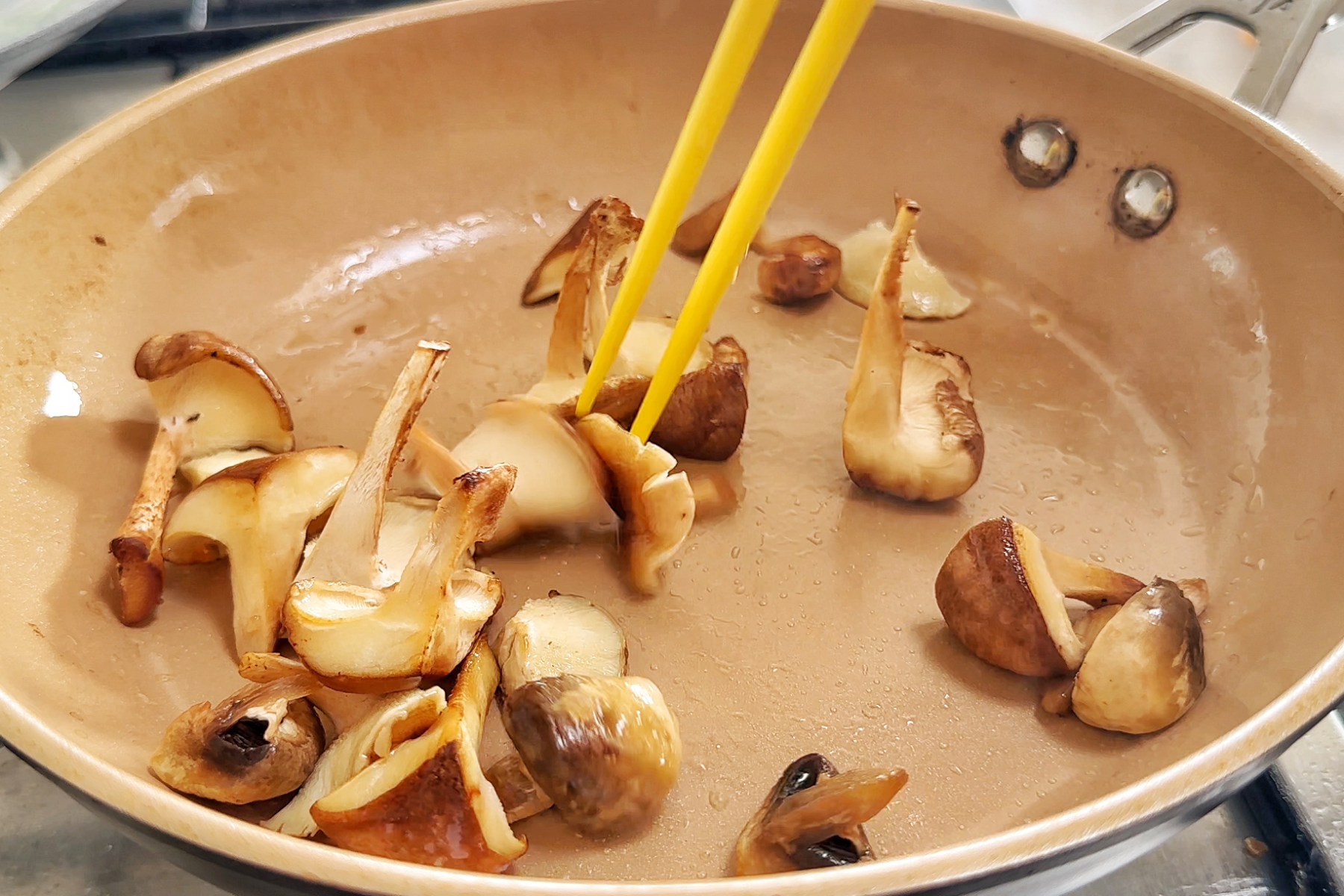 Frying shiitake mushrooms in a non-stick pan.
