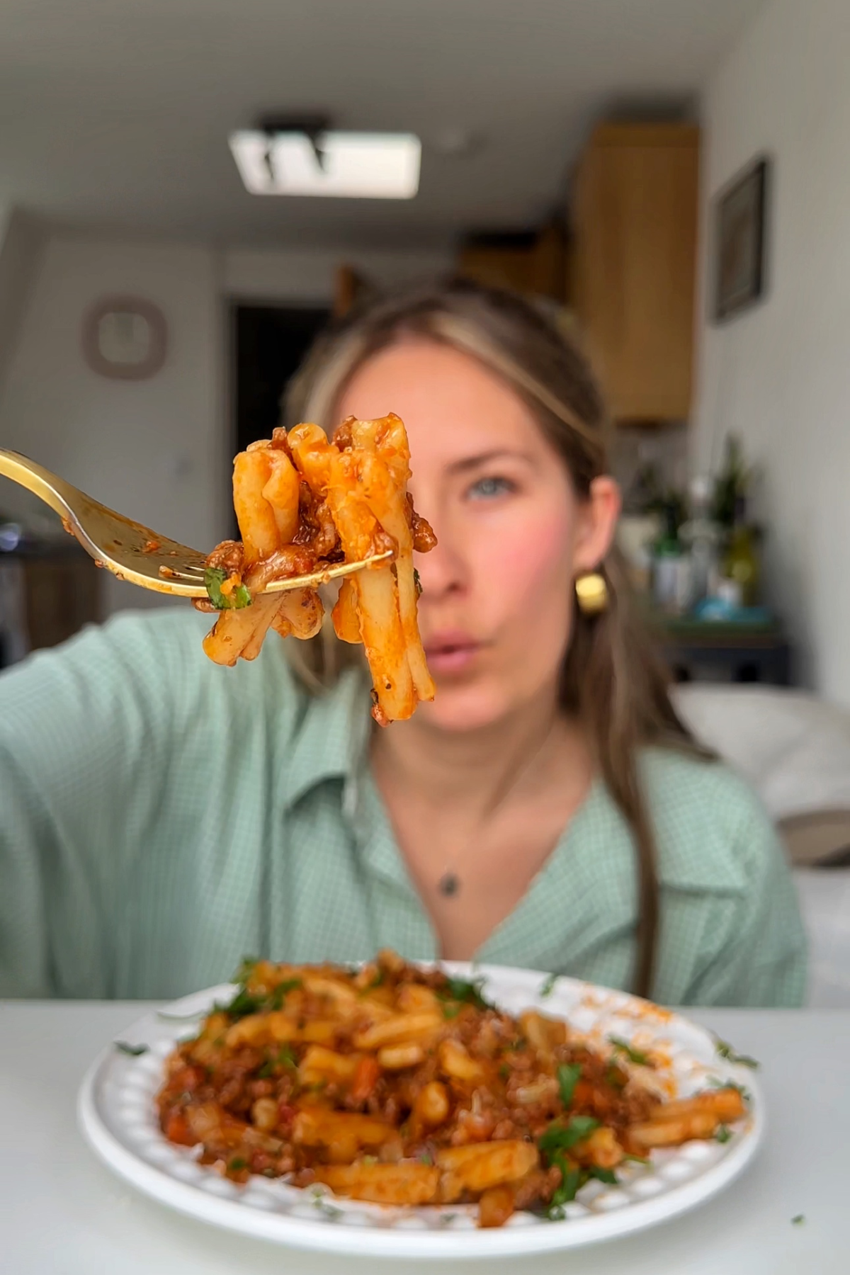 Emily Roz holding up casarecce bolognese.