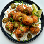 Plate of air fryer chicken meatballs with buffalo sauce and blue sauce.
